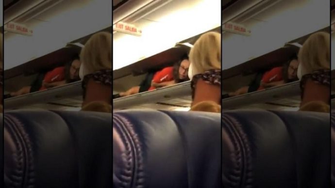 Southwest flight attendant welcomes passengers being in the overhead bin